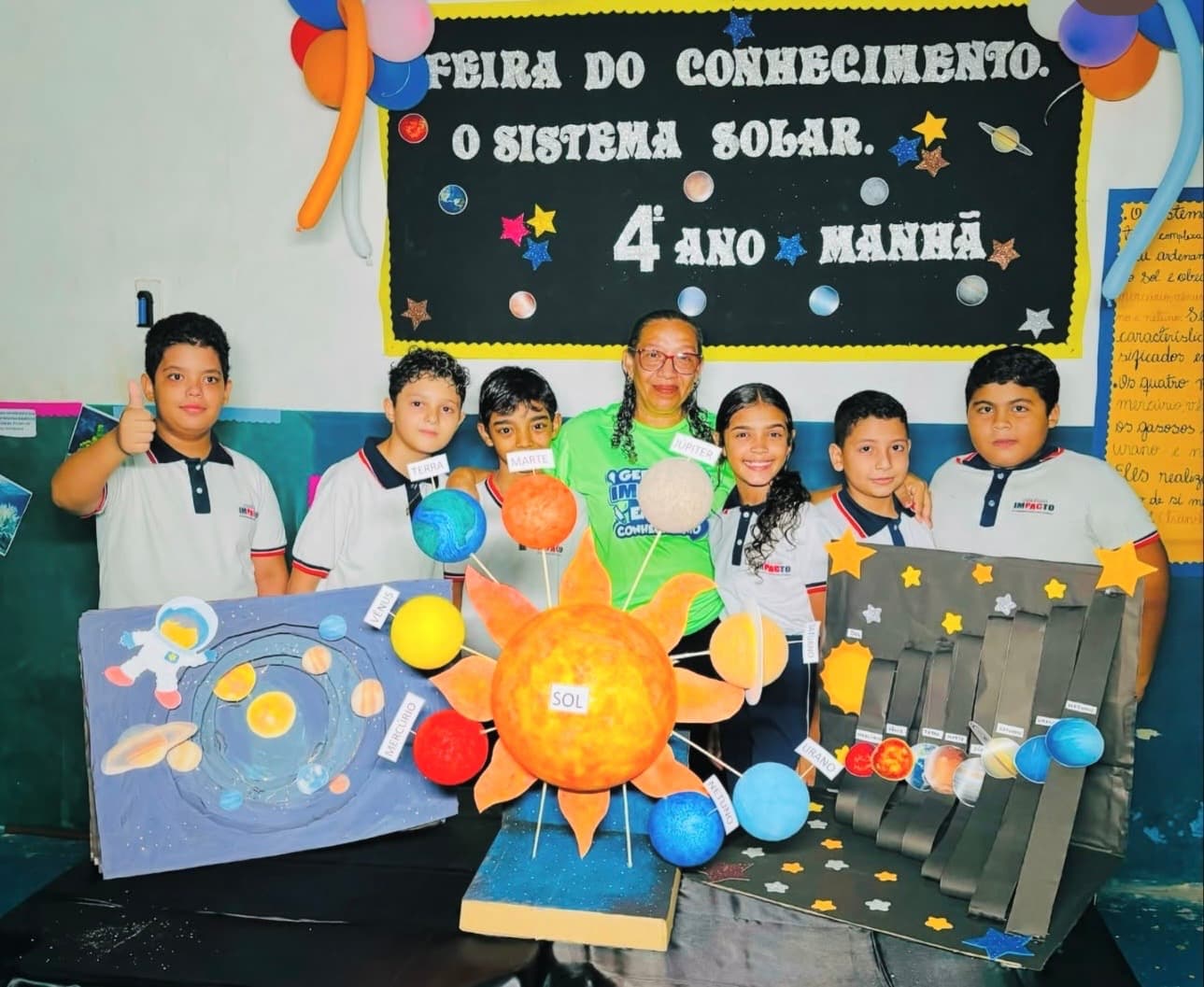Alunos do Colégio Impacto na Feira do Conhecimento, com maquete do sistema solar